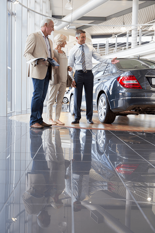 salesman-showing-couple-a-car-in-car-dealership-sh-2026-01-11-09-52-25-utc.png