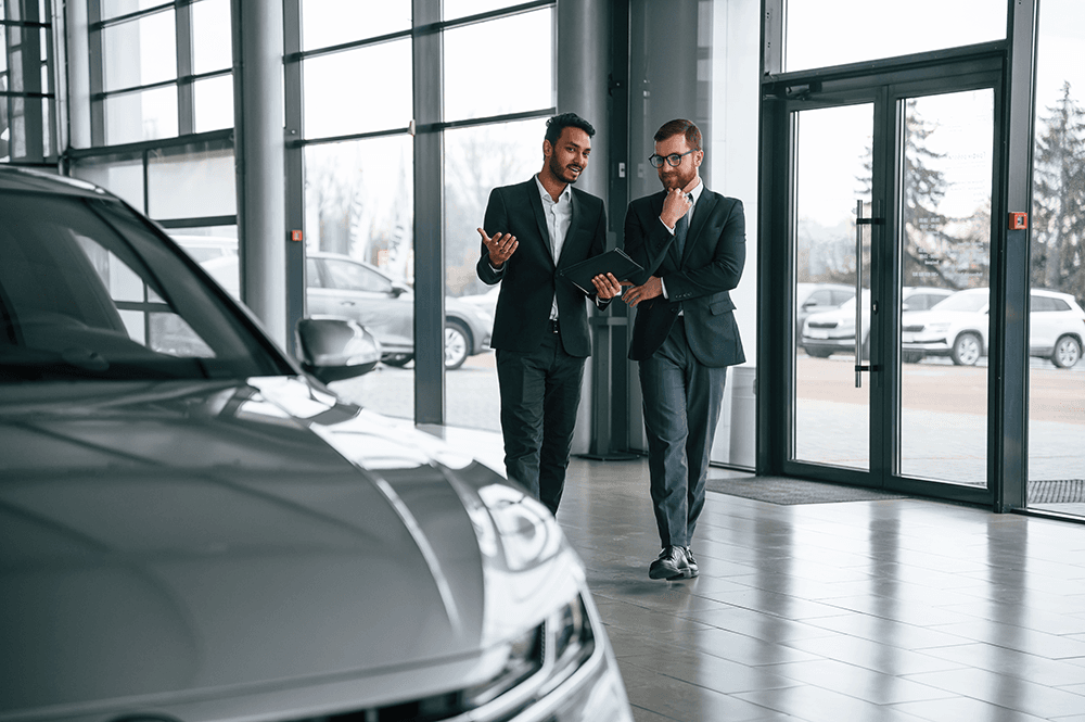 salesmen-discuss-new-car-models-in-showroom-2026-01-08-23-56-20-utc.png